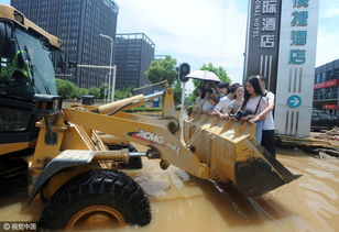 湖北武汉市区渍水 市民靠铲车出行 