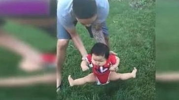 1岁萌娃逛公园,爸爸想把他放草坪上,接下来宝宝的举动笑翻妈妈