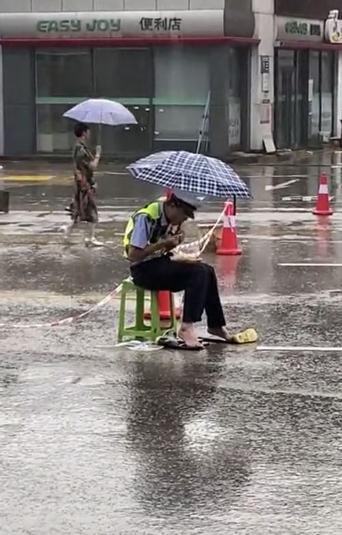 恩施交警雨中光脚扒饭 走红 连续执勤胶鞋进了水,就脱了