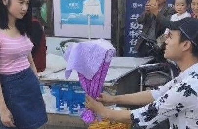 辽宁营口现“痴情哥” 街头举牌求女友原谅