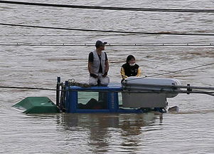 日本罕见暴雨致洪水泛滥 居民抱狗爬屋顶等救援