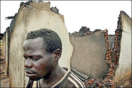 刚果男子走过被毁家园 