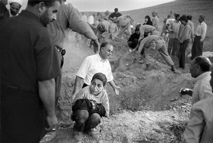 年度最佳新闻照片 地震之后伊朗男孩在父亲的墓地旁哀悼 